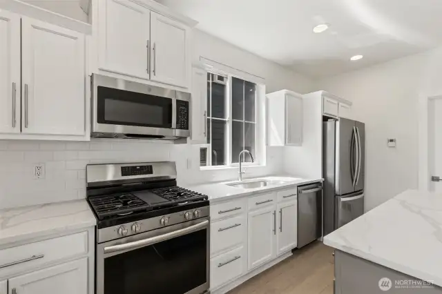 Chef-inspired gas cooktop with center griddle offers versatile cooking options, framed by modern finishes and a sleek design, perfect for weeknight meals or weekend gatherings.