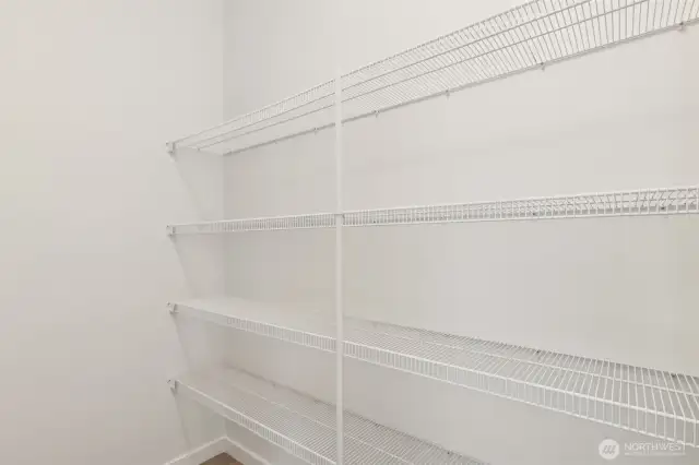 Spacious walk-in pantry offers ample storage for dry goods, kitchen essentials & small appliances—keeping everything organized and within easy reach.