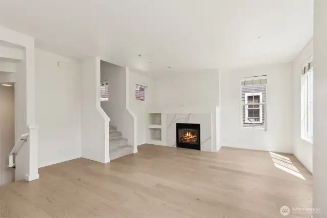 Bright and inviting, this additional view of the living room showcases the open layout, cozy gas fireplace, and natural light—creating a comfortable space to relax or entertain.