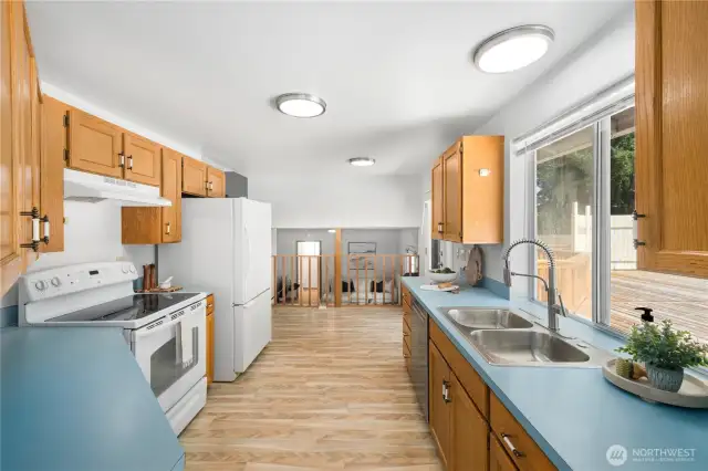Beyond the kitchen and at the railing, there is space for a breakfast nook.