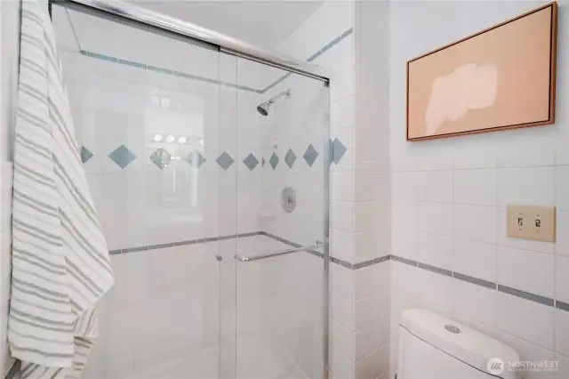 En-suite bathroom connected to the primary bedroom. Private shower and water closet with heat lamp and exhaust fan.