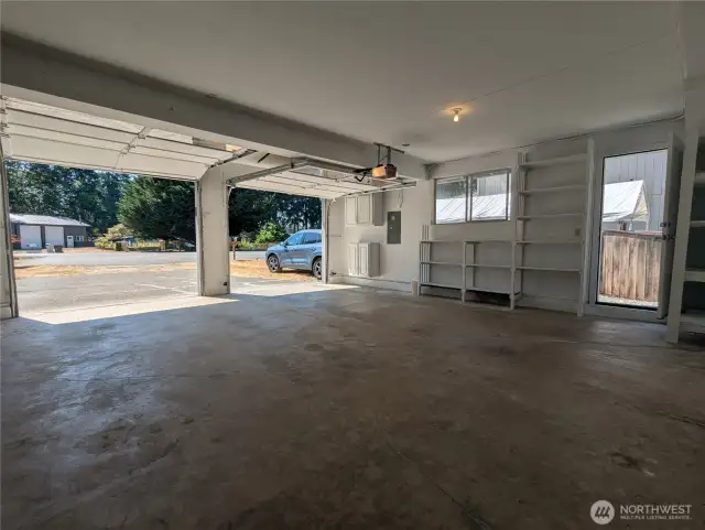 Two-car attached garage with exterior door to the side yard. The blue SUV indicates ample RV/trailer parking space, with additional parking beside the garage and inside the gate.