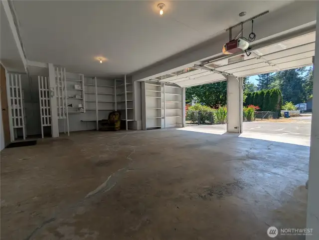 Storage shelving adjacent to the parking spaces could be tranformed for a workbench or exercise equipment, offering a practical addition to the property. An interior door to the main house is located on the left side.