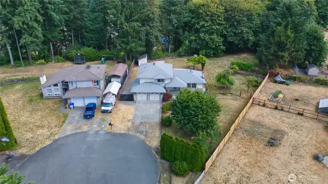 The property extends beyond the back fence and includes most of the trees behind the yard.