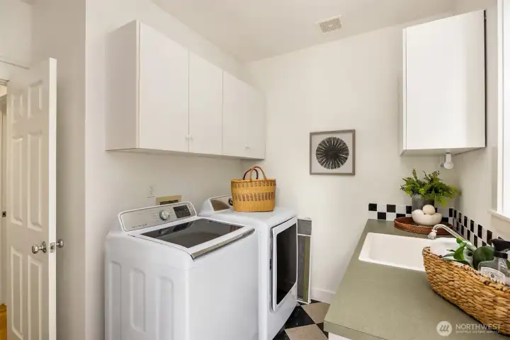 The laundry/utility room with storage, counter space and a mop sink.