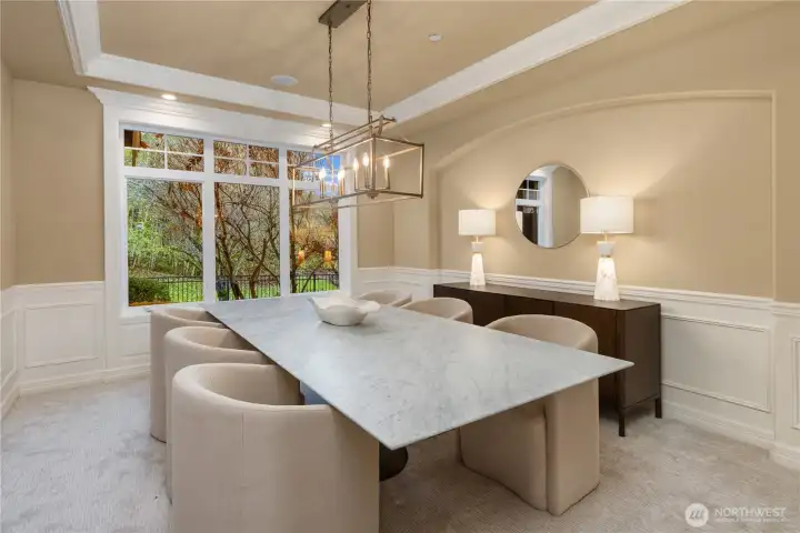 The formal dining room showcases the architectural details and finishes. Crown molding, wainscotting run throughout this home.