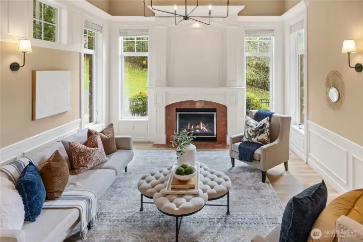 The formal living room with it's vaulted ceilings and high windows, perfectly frame the gorgeous wood and marble trimmed fireplace.