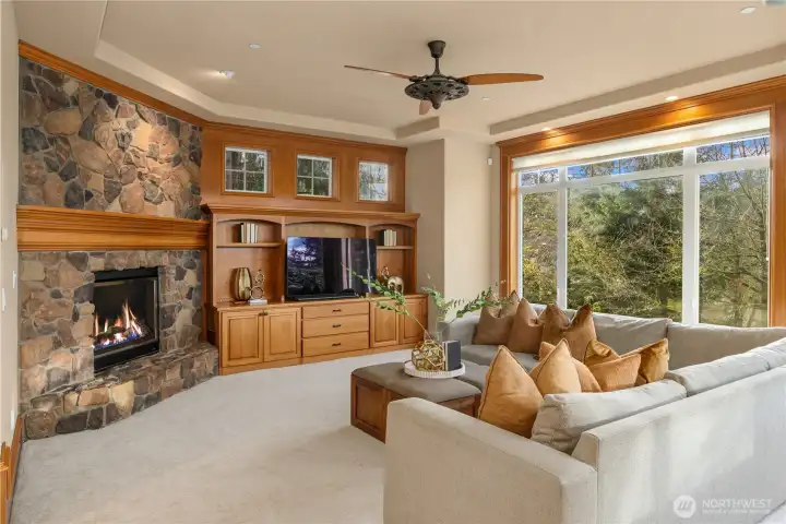 A stunning River Rock fireplace, and built in cabinetry anchor this wide open family room, adjacent to the kitchen.