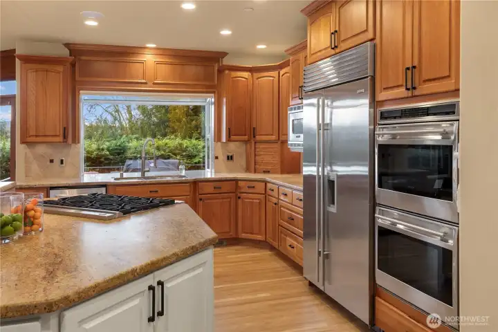Warm wood cabinetry offer so much storage. The appliances are in the perfect places for multiple 'chefs' to work together.