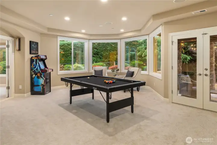 A complete walk-out lower level is light and bright, and the entertainers dream. Here is the generous 'game room', with double doors to the massive outdoor living spaces.