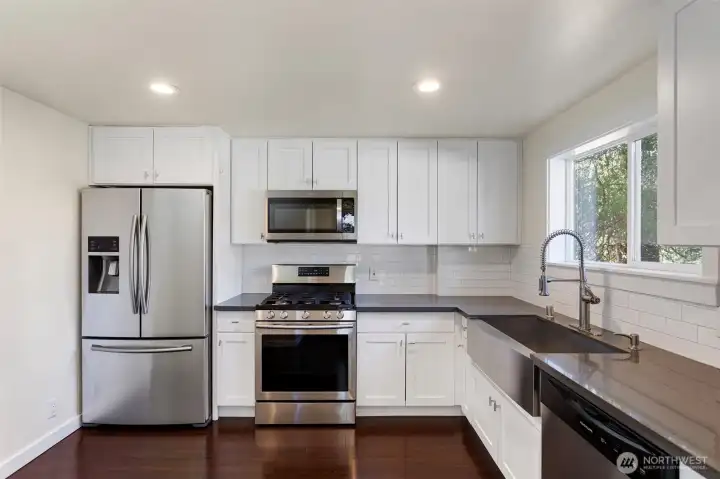 Functional kitchen with generous counter space  and storage looking out into a private back yard.