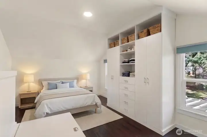Upper level primary bedroom #3 with custom built-in storage looking out to a private back yard.
