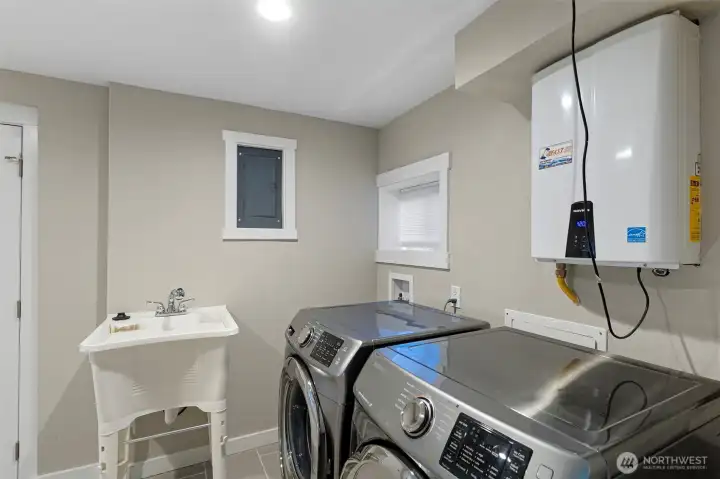 The layout of the large scale laudry room is intelligently zoned for maximum efficiency, offering ample space for sorting and organizing.    A deep, integrated utility sink provides a high-performance area for soaking and specialized care.