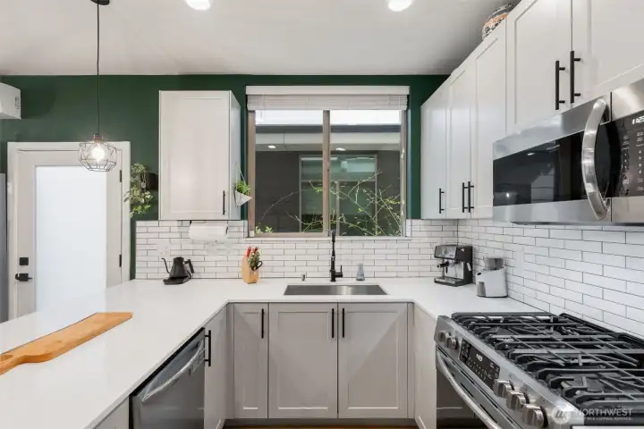 All stainless appliances including a 5- burner gas range and full vented fan in the microwave.