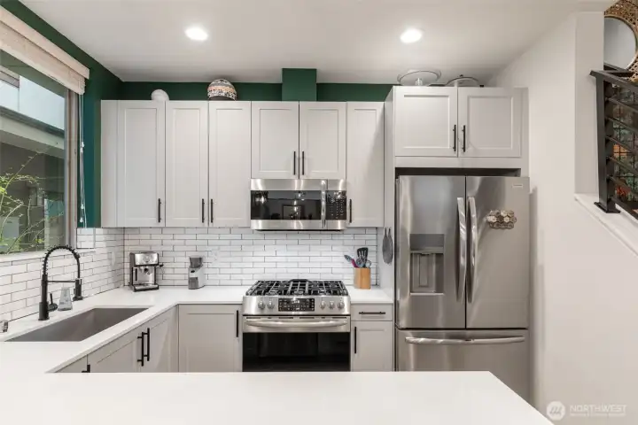 Subway tile backsplash and high cabinets to maximize storage.