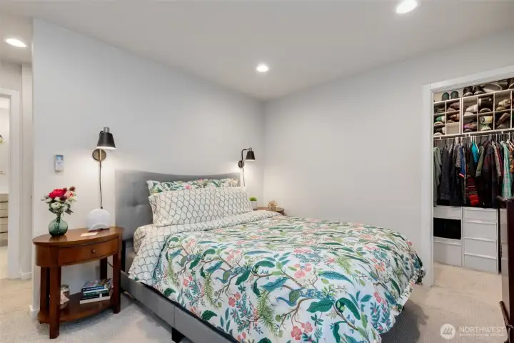 Walk-in closet has a closet system already installed.