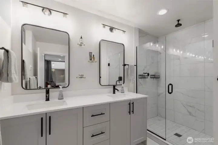 Primary bath with double vanity and custom tiled shower.