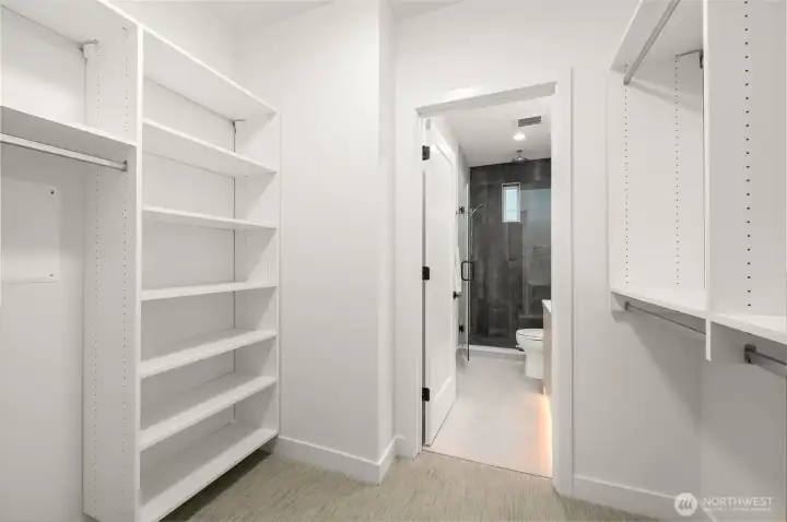 Walk-in closet with custom built-in shelving for optimal organization and storage.