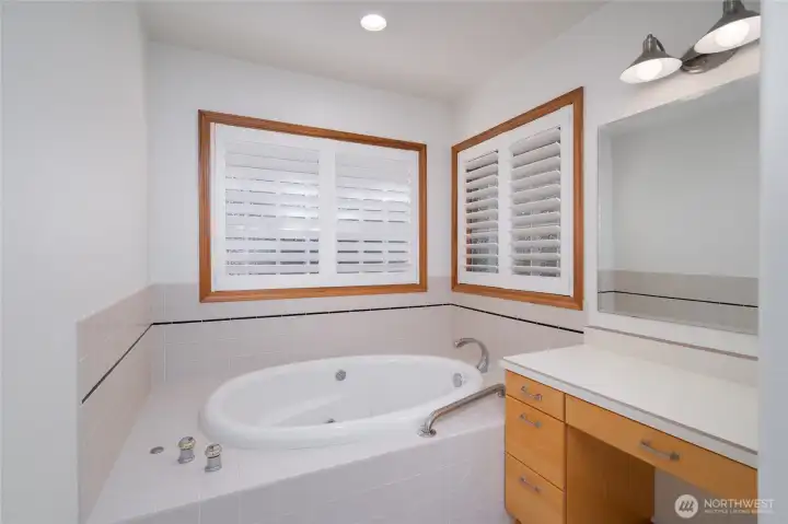 Spa-like bath with soaking tub and bright natural light. Spa-like bath with soaking tub and bright natural light.