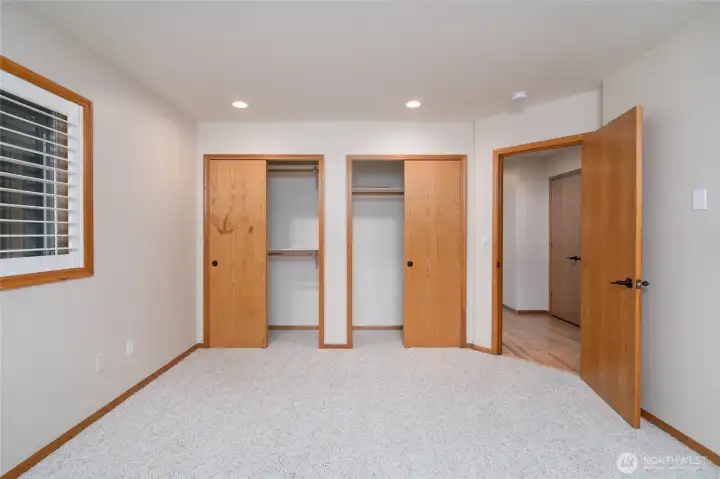 Bright lower-level bedroom with dual closets and soft natural light. Bright lower-level bedroom with dual closets and soft natural light.