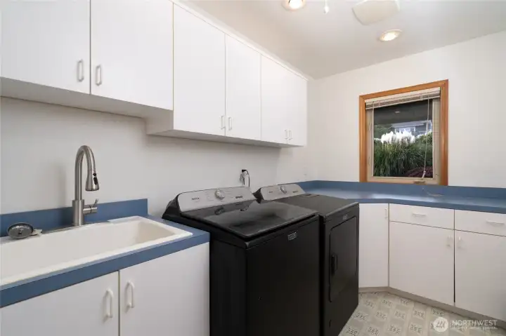 Spacious laundry room with utility sink and abundant storage cabinetry. Spacious laundry room with utility sink and abundant storage cabinetry.