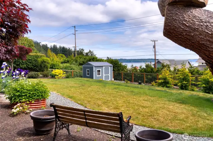 Expansive backyard with water views, lush gardens, and storage shed. Expansive backyard with water views, lush gardens, and storage shed.