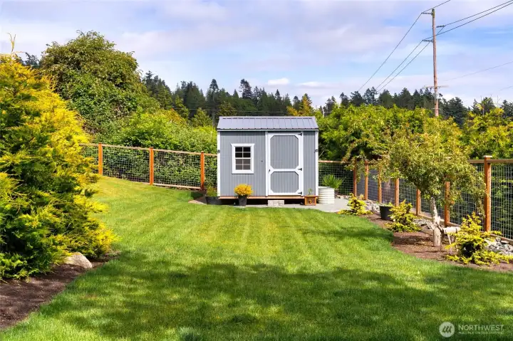 Expansive fenced yard with garden space and handy storage shed. Expansive fenced yard with garden space and handy storage shed.