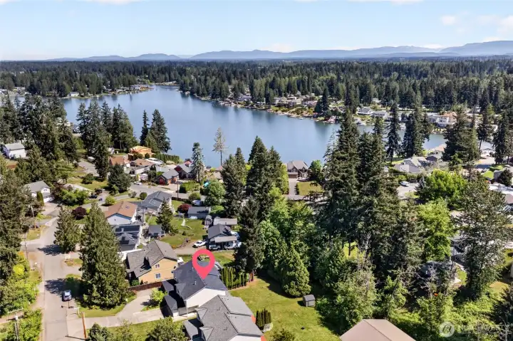 Aerial view showcasing the duplex’s prime location near Church Lake, surrounded by mature evergreens and established homes. Enjoy a peaceful neighborhood setting with convenient access to recreation, scenic water views, and the natural beauty that makes Lake Tapps living so desirable.