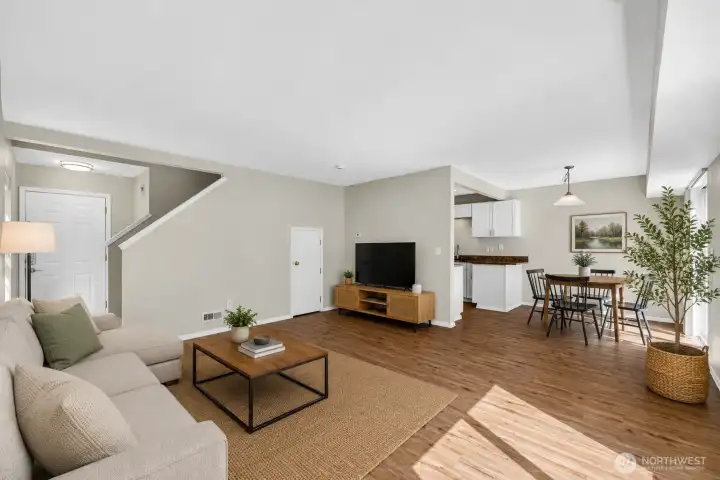 Open-concept living and dining areas offer an inviting layout with abundant natural light, durable flooring, and seamless flow for everyday living or entertaining. Spacious design connects easily to the kitchen, patio access, and private backyard setting.