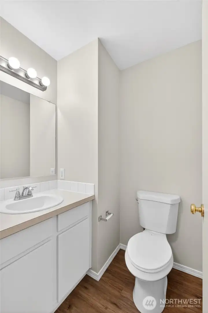 Convenient main-floor powder room with clean finishes, easy-maintenance flooring, and functional layout for guests and everyday use. Bright vanity lighting and neutral tones create a fresh, move-in ready feel.