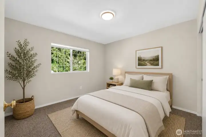Additional secondary bedroom with neutral finishes, soft natural light, and flexible space for guests, a home office, or everyday living. Large window overlooks mature greenery, adding a peaceful residential feel.