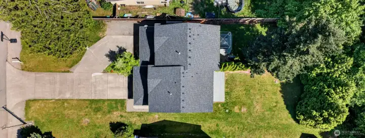 Aerial overview highlights the duplex’s generous lot size, expansive backyard space, and tucked-away setting at the end of a quiet cul-de-sac. Surrounded by mature trees and neighboring green space, the property offers privacy, extra parking, and room to enjoy the outdoors.