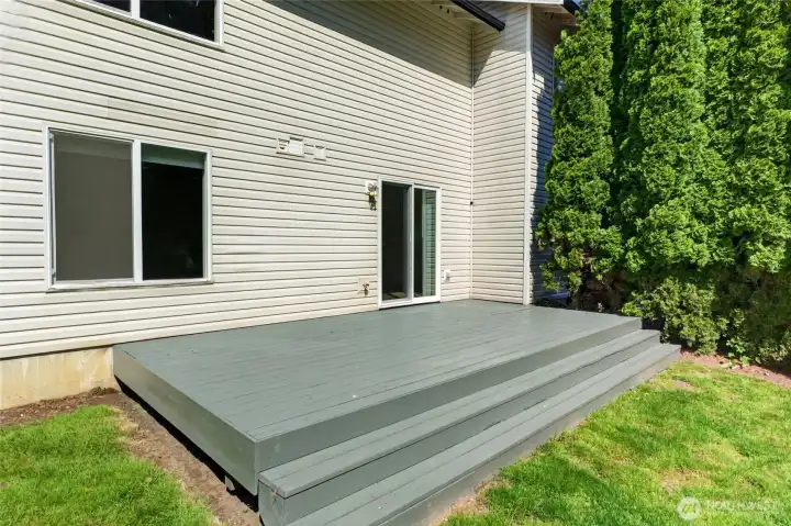 Expansive back deck creates a seamless extension of the living space, offering the perfect setting for outdoor dining, entertaining, or relaxing while enjoying the privacy of the tree-lined backyard.