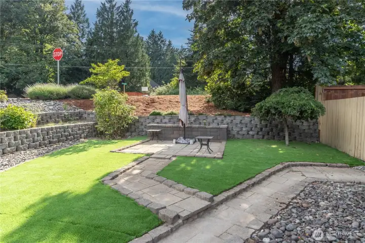 Low maintenance artificial tuff adorn most of the yard. This is the front yard with paver walkway to a sitting area.
