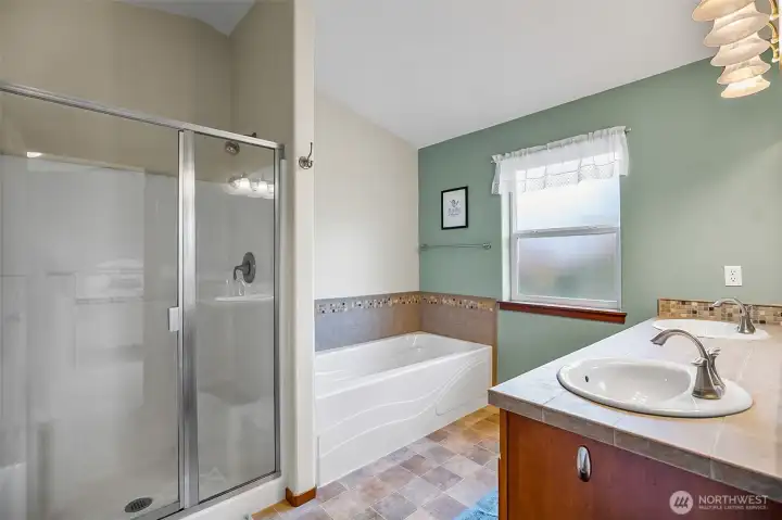 Primary private bathroom with dual sink vanity and soaking tub.