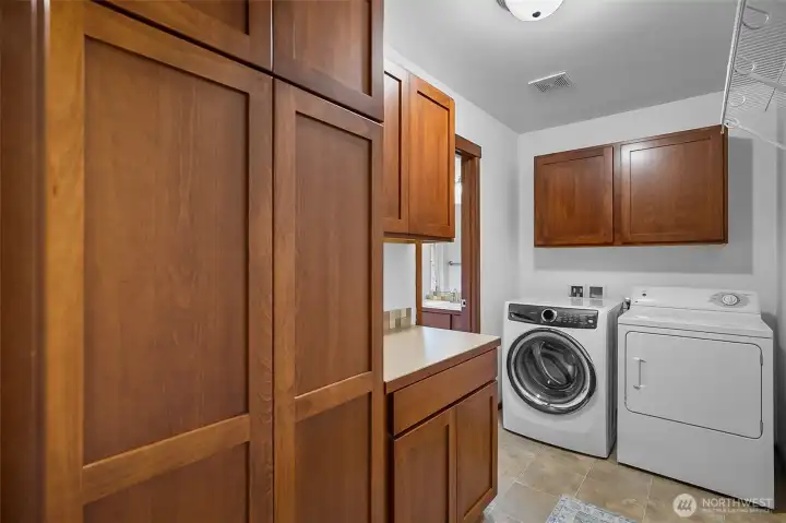 Laundry room with cabinets for storage.
