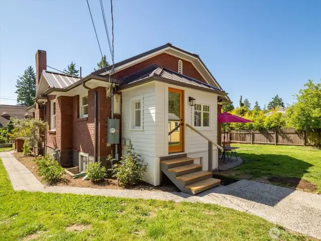 Sweet enclosed back porch!  The off-street parking is next to the fence on the east side here.