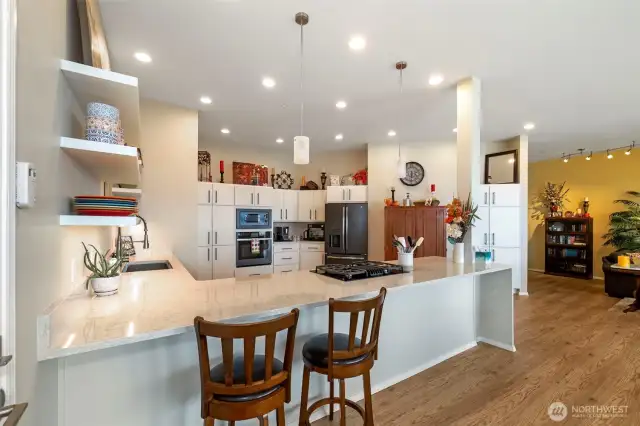 Another view of this amazing kitchen - storage and more storage. Quartz countertops and slide out pan drawers, beautiful pendent lights.