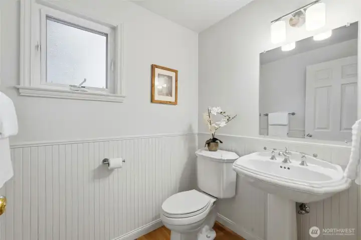 Downstairs powder room is a classic with wainscot and pedestal sink.