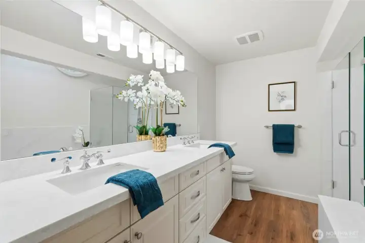 Spa-inspired Primary suite features dual sink vanity with storage galore. Everything is new ~ lighting, flooring, plumbing fixtures, quartz, walk-in shower, and jetted tub.
