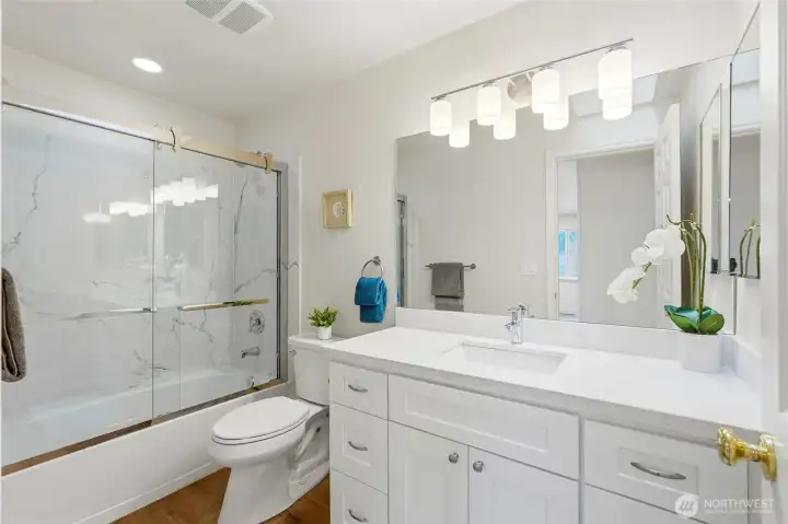 2nd completely remodeled bath with new everything ~ tub/shower with quartz surround and heavy duty glass sliding door, lighting, cabinets, toilet, counters, etc.