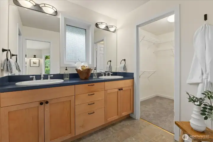 Primary bath features double sinks and access to one of the two walk-in closet.