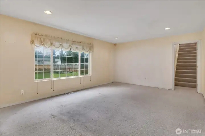Family room with rear staircase leading up to the bonus room