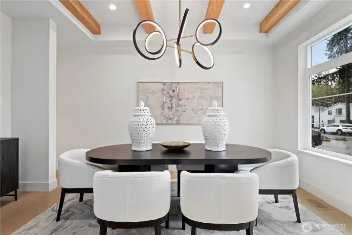 Formal dining with exposed beams, designer lighting and a clean, modern aesthetic.