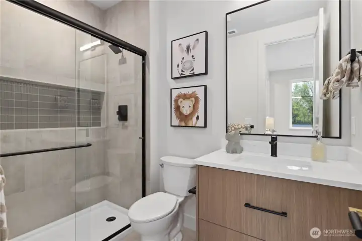 Ensuite bathroom with nice long shower and full-length inset champoo niche with accent tiling.