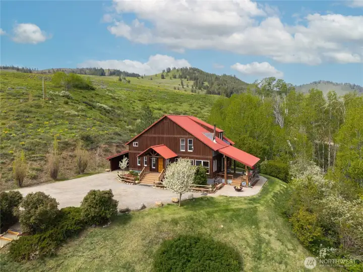 Custom home nestled in a natural aspen grove overlooking the Rendezvous, with a seasonal creek below and a beautifully maintained setting. Thoughtfully positioned for easy access, featuring a covered deck, stone patio, inviting main entry, colorful landscaping, and an automatic in-ground sprinkler system.