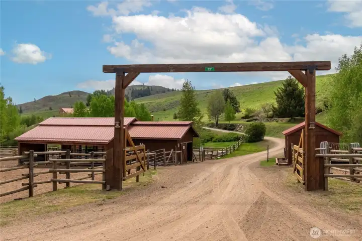 Gated entry framed by classic wood fencing opens to a high chaparral setting, welcoming you into a versatile Upper Rendezvous property designed for year-round Western country living and recreation.