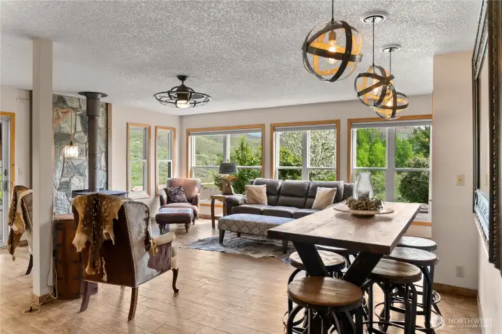 Bright, open dining area wrapped in windows capturing sweeping valley views offering a welcoming dining experience.