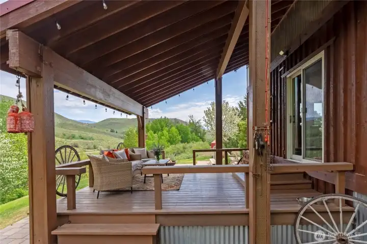Inviting covered deck extends the living space outdoors, offering a comfortable setting for gathering and year-round enjoyment with peaceful views across the surrounding landscape.