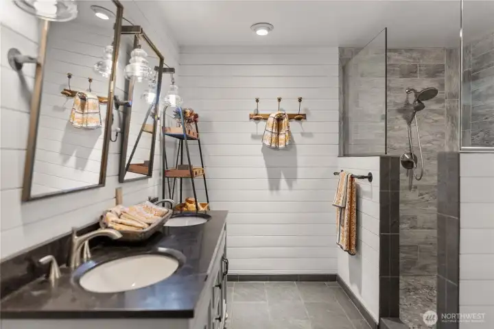Spacious main floor bath with custom tile shower and double vanity, blending clean finishes with a refined, functional design.